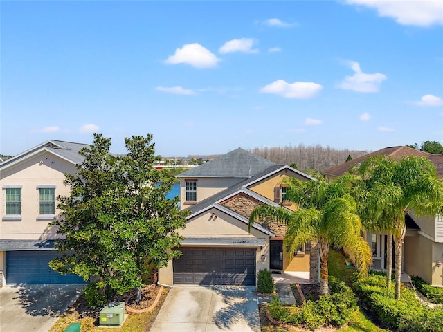 view of front of home with concrete driveway, an attached garage, and stucco siding