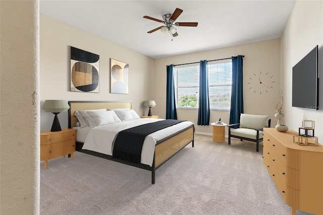 bedroom featuring light carpet and a ceiling fan