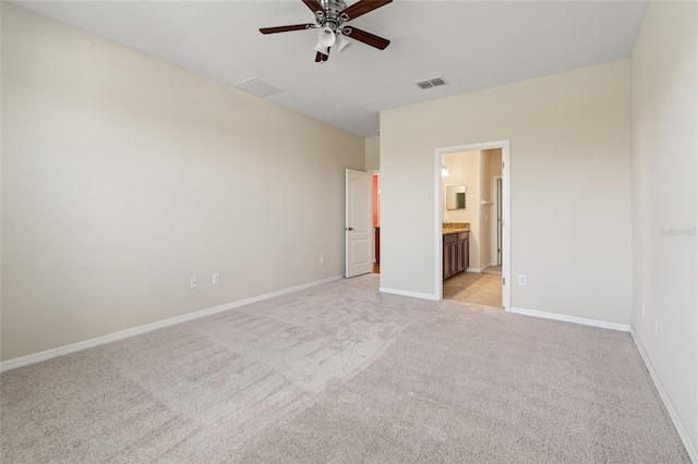 unfurnished bedroom with ceiling fan, light colored carpet, visible vents, baseboards, and ensuite bath