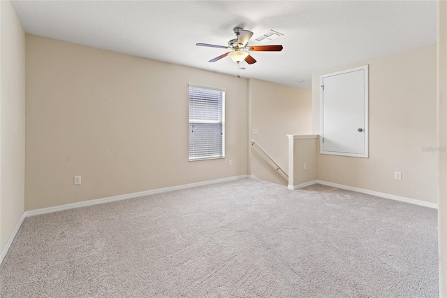 empty room with baseboards, visible vents, a ceiling fan, and light colored carpet