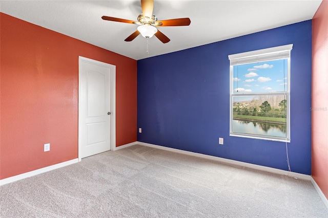 unfurnished room featuring a ceiling fan, light colored carpet, and baseboards