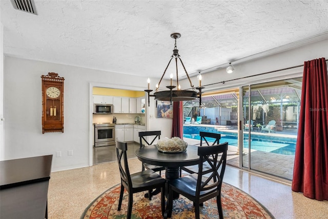 dining room with light speckled floor, visible vents, a textured ceiling, a chandelier, and baseboards