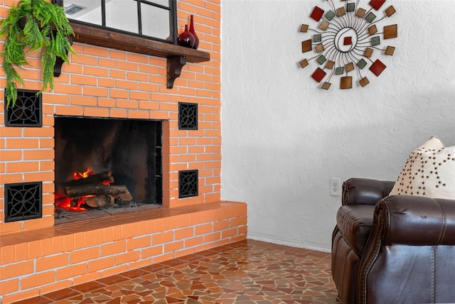 living room featuring a brick fireplace, a textured wall, and baseboards