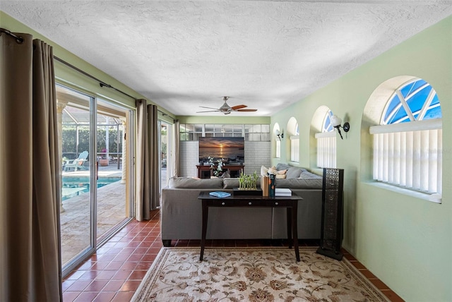 living room featuring a textured ceiling, a ceiling fan, and tile patterned floors