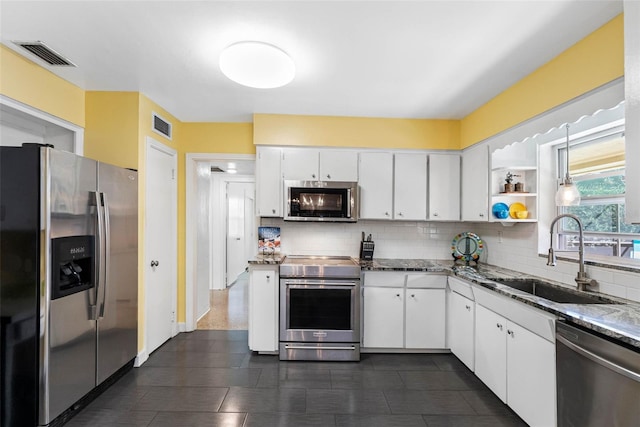 kitchen featuring open shelves, stainless steel appliances, visible vents, white cabinetry, and a sink