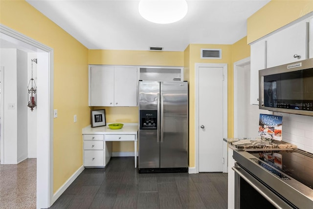 kitchen with stainless steel appliances, light countertops, white cabinets, and visible vents