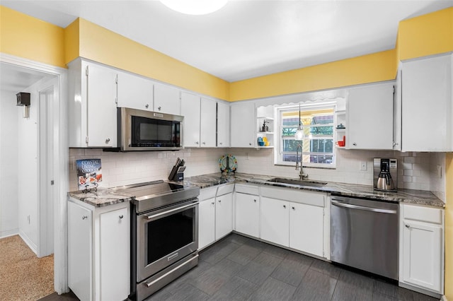 kitchen featuring tasteful backsplash, white cabinets, appliances with stainless steel finishes, open shelves, and a sink