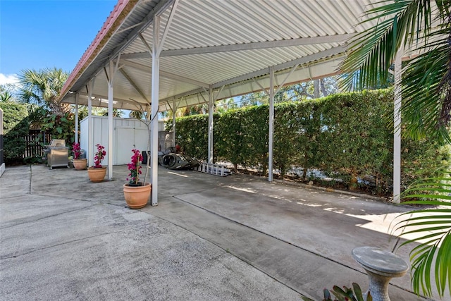 view of patio with an outbuilding, a shed, area for grilling, and fence