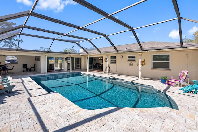 outdoor pool featuring glass enclosure and a patio area