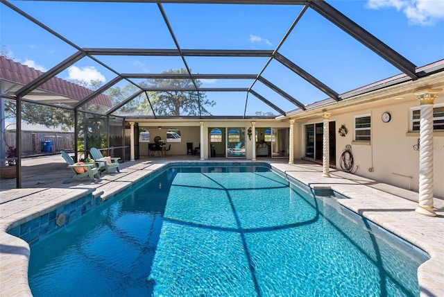 pool with glass enclosure, a patio area, ceiling fan, and fence