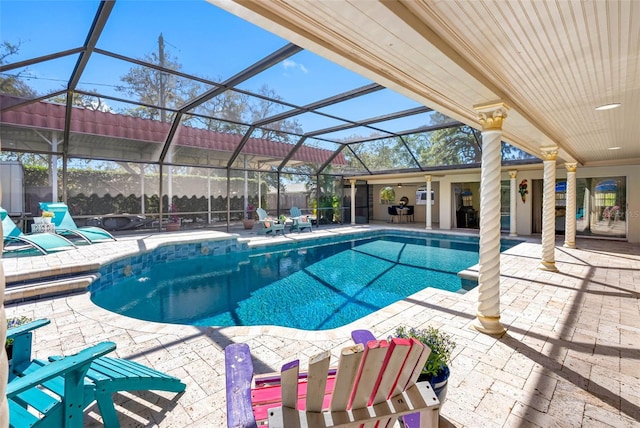 view of swimming pool with glass enclosure, a patio, and a fenced in pool