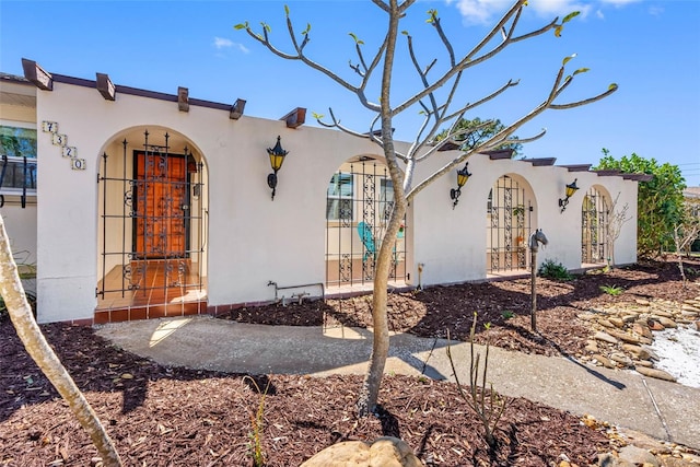 exterior space with a fenced front yard, a gate, and stucco siding