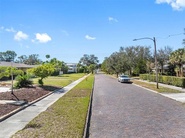 view of street with curbs, sidewalks, and street lights