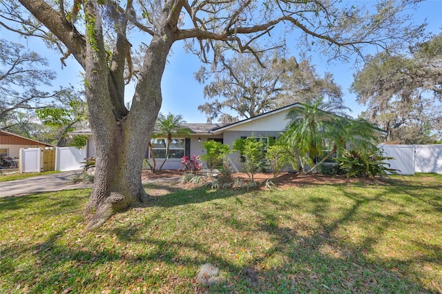 view of front of house with driveway, a front yard, fence, and a gate