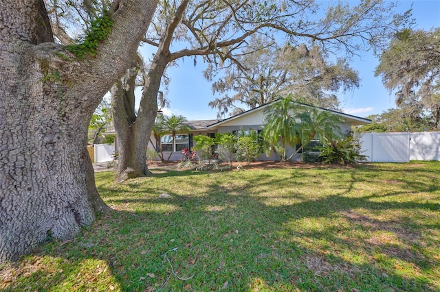 view of front facade featuring fence and a front lawn