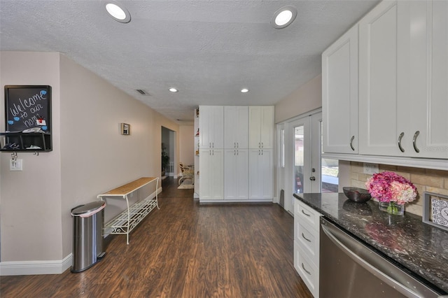 kitchen featuring dark wood-type flooring, white cabinetry, dark stone counters, dishwasher, and baseboards