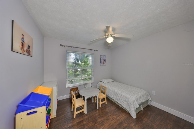 bedroom featuring a textured ceiling, baseboards, and wood finished floors