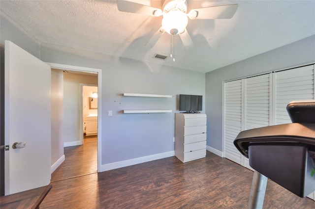 office with baseboards, a textured ceiling, visible vents, and wood finished floors