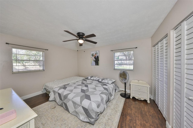 bedroom featuring ceiling fan, a textured ceiling, baseboards, and wood finished floors