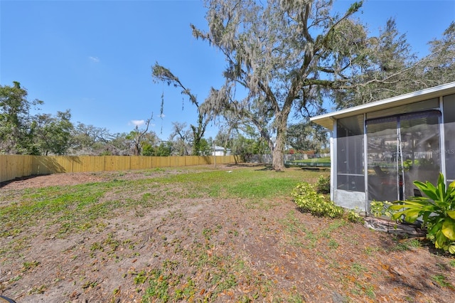 view of yard featuring a sunroom and fence