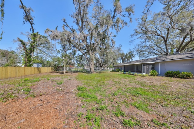 view of yard featuring a sunroom and fence