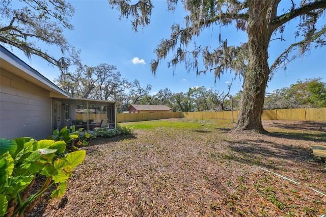 view of yard with a sunroom and a fenced backyard