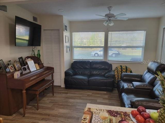 living area featuring ceiling fan, wood finished floors, and visible vents