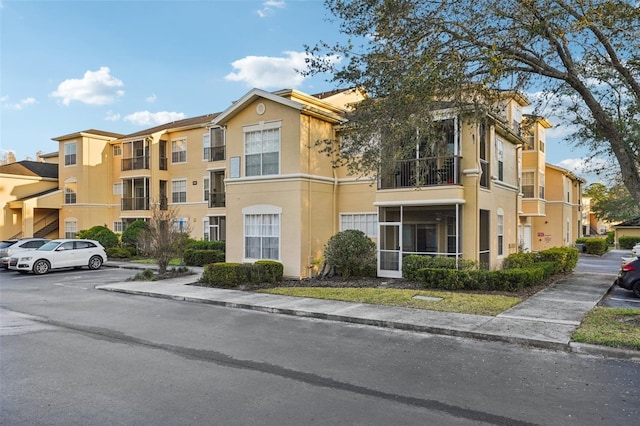 view of property with uncovered parking and a residential view