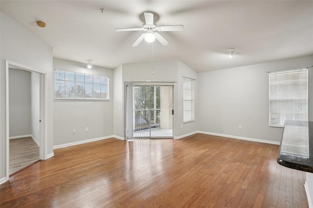 unfurnished living room with a ceiling fan, wood-type flooring, and baseboards