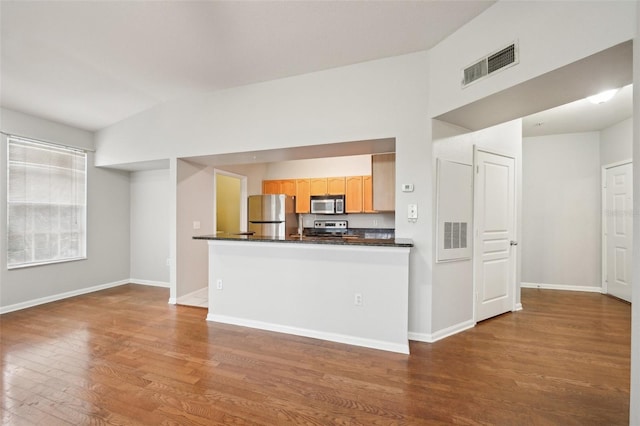 kitchen featuring baseboards, visible vents, dark countertops, appliances with stainless steel finishes, and wood finished floors