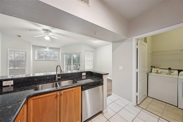 kitchen with washer and dryer, brown cabinets, dishwasher, and a sink