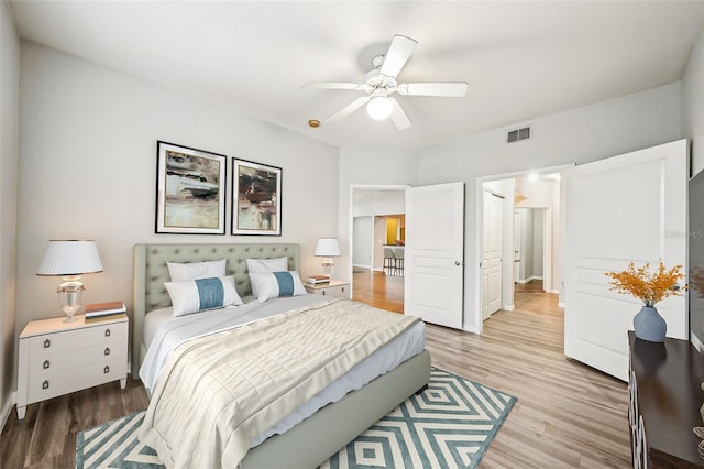 bedroom with baseboards, a ceiling fan, visible vents, and light wood-style floors