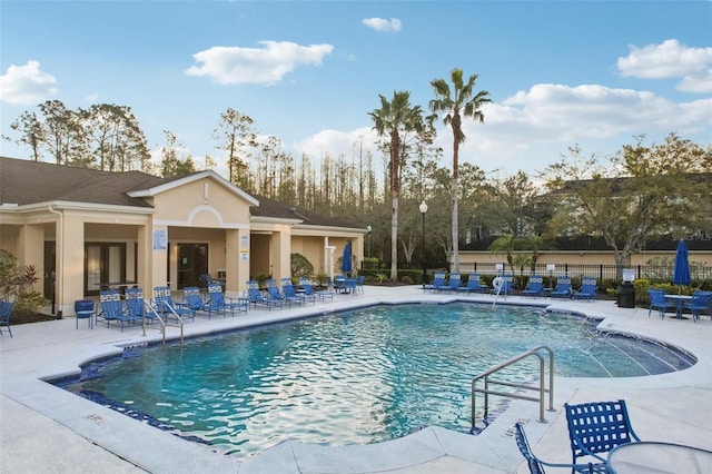 community pool with fence and a patio