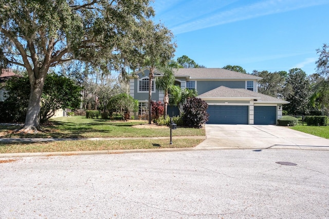 traditional-style home with an attached garage, concrete driveway, and a front yard