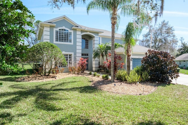 view of front facade featuring a garage, a front lawn, and stucco siding