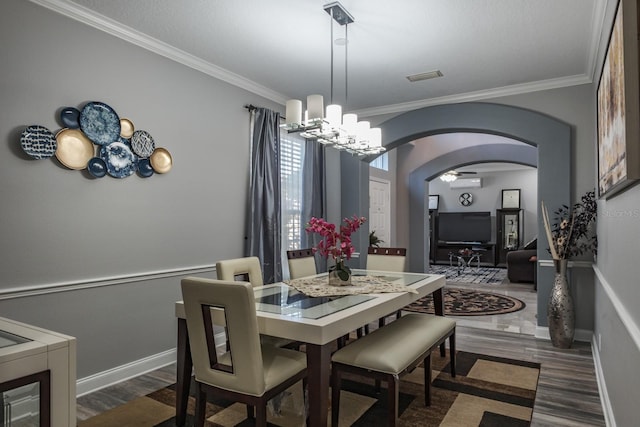 dining room featuring arched walkways, dark wood-type flooring, visible vents, and crown molding