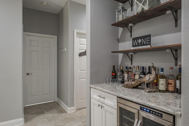 bar with a dry bar, wine cooler, and baseboards