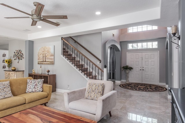 foyer with baseboards, stairs, arched walkways, and recessed lighting