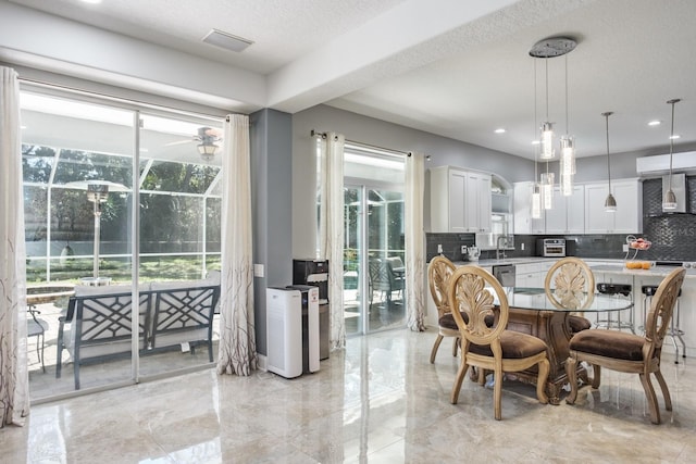 dining room featuring a textured ceiling, a toaster, visible vents, and a healthy amount of sunlight