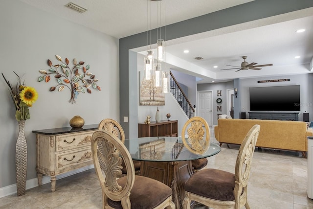 dining space featuring stairs, visible vents, a tray ceiling, and recessed lighting