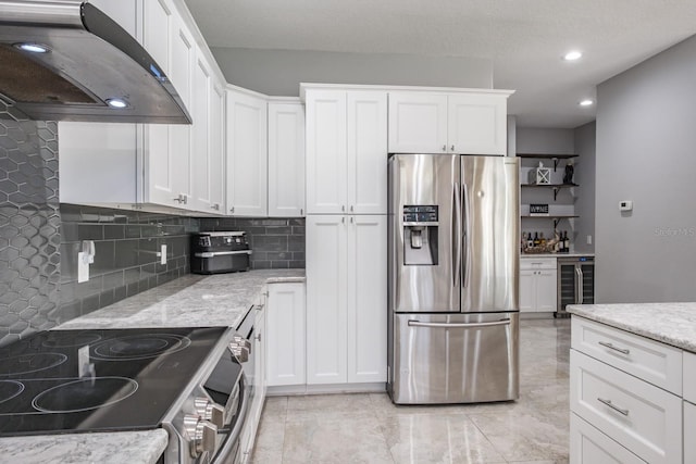 kitchen with range hood, wine cooler, appliances with stainless steel finishes, white cabinets, and light stone countertops