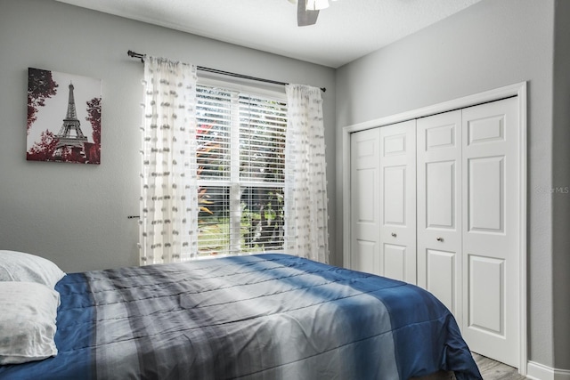 bedroom with a ceiling fan, a closet, and wood finished floors