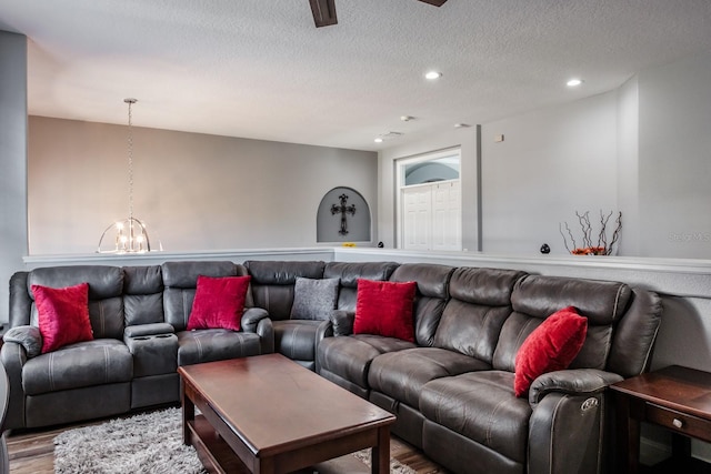 living area featuring a chandelier, recessed lighting, a textured ceiling, and wood finished floors