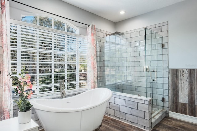 bathroom featuring recessed lighting, a soaking tub, wood finished floors, and a shower stall