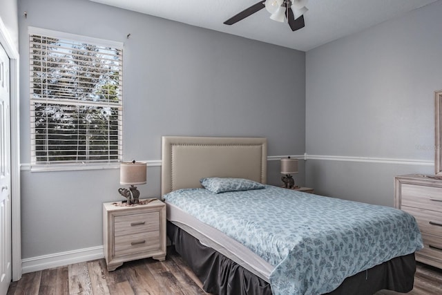 bedroom featuring dark wood finished floors, a ceiling fan, and baseboards