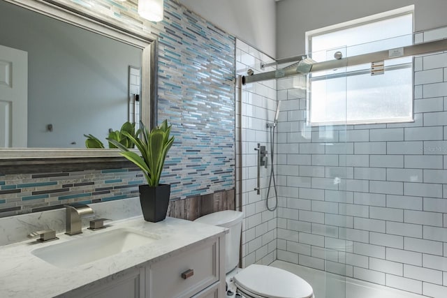 bathroom featuring tile walls, backsplash, toilet, a tile shower, and vanity