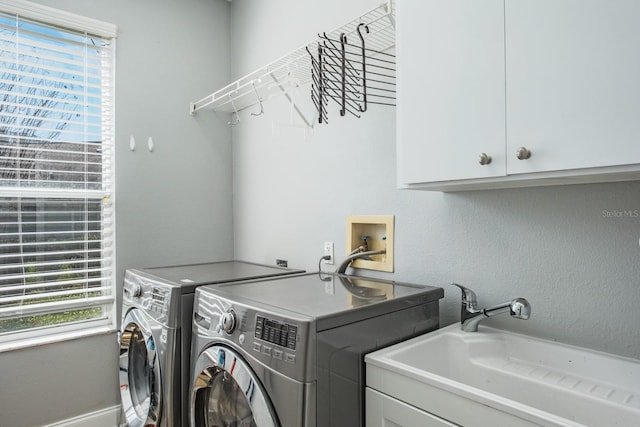 laundry area with cabinet space, plenty of natural light, a sink, and independent washer and dryer