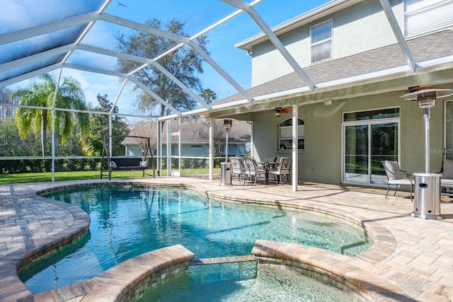 view of pool featuring a pool with connected hot tub, a patio area, a lanai, and a ceiling fan