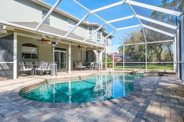 outdoor pool featuring a patio area, glass enclosure, and ceiling fan