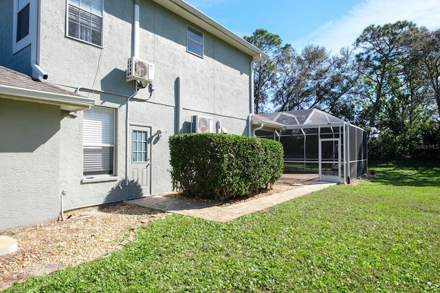 view of home's exterior featuring glass enclosure, a lawn, and stucco siding